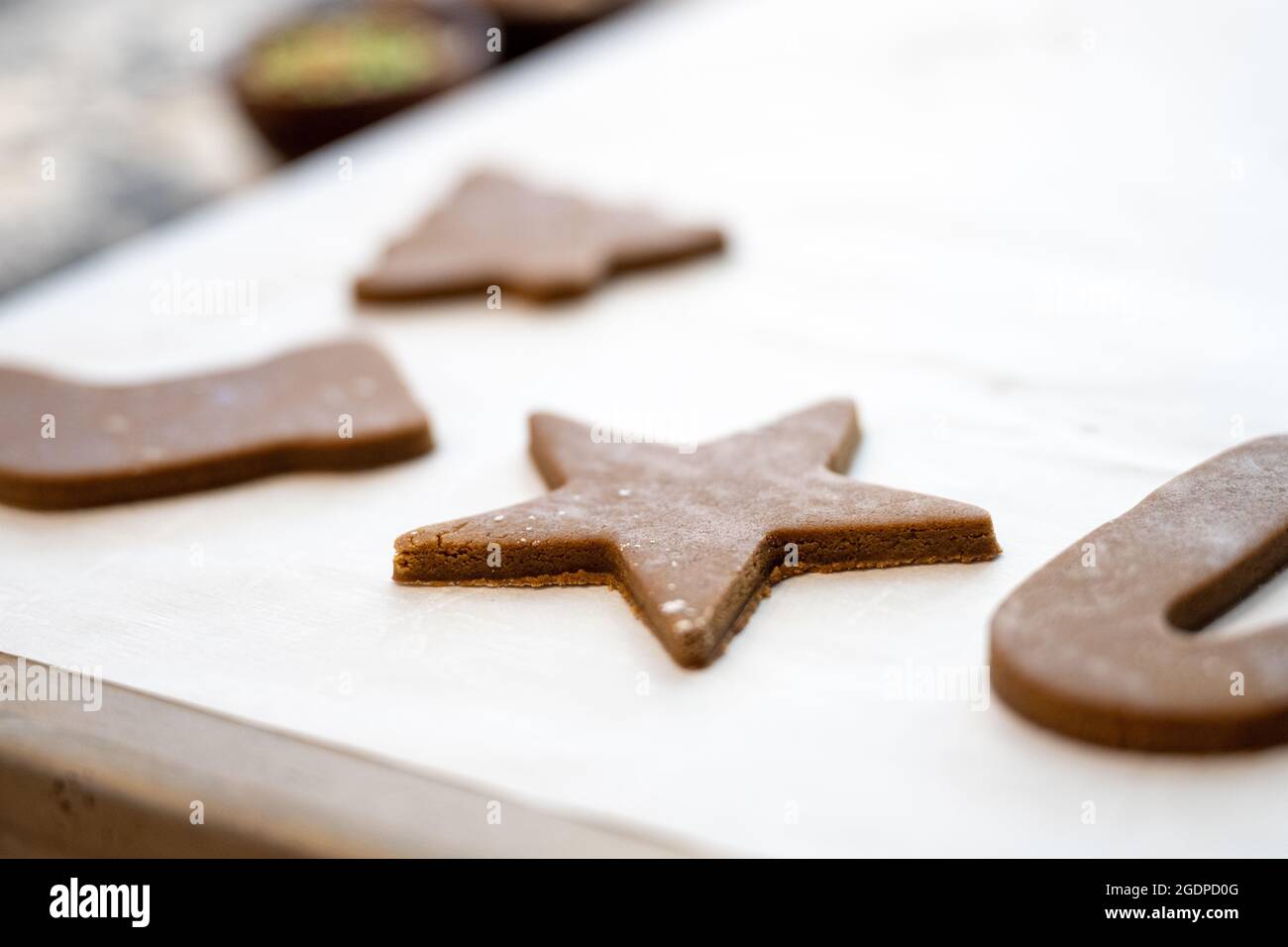 Holiday Cutout Cookies on Parchment Paper and Baking Sheet Stock Photo