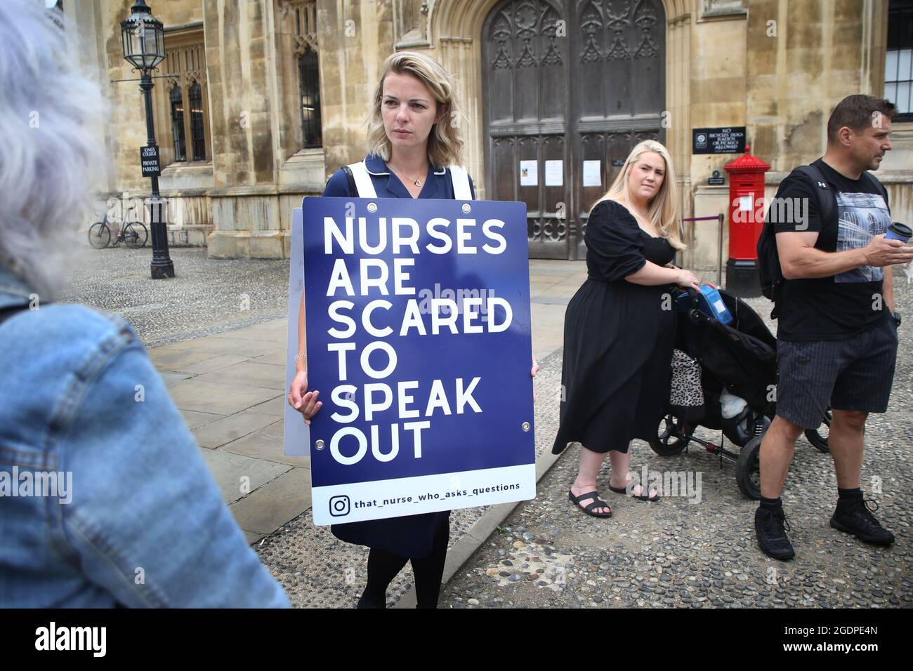 Nurse, Jenna Platt talks to supporters and members of the public at Kings College, Cambridge as she reaches her landmark 50th UK city.Jenna is currently walking around the UK wearing a sandwich board that encourages debate, visiting all 69 cities to highlight how Covid care has left nurses unhappy and too scared to question policy for fear of losing their jobs. Some health workers have spoken of bullying, coercion and being ostracised. Many feel if they ask questions, they are seen as being part of the problem. Jenna delivered a letter of complaint to The Nursing Midwifery Council in London be Stock Photo