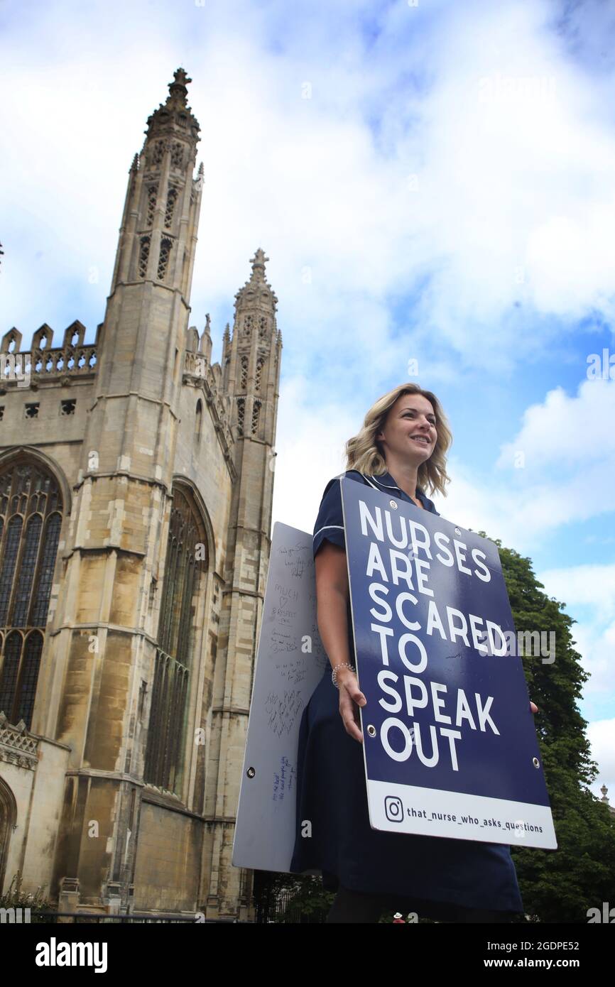 Nurse, Jenna Platt at Kings College, Cambridge as she reaches her landmark 50th UK city.Jenna is currently walking around the UK wearing a sandwich board that encourages debate, visiting all 69 cities to highlight how Covid care has left nurses unhappy and too scared to question policy for fear of losing their jobs. Some health workers have spoken of bullying, coercion and being ostracised. Many feel if they ask questions, they are seen as being part of the problem. Jenna delivered a letter of complaint to The Nursing Midwifery Council in London before she embarked on her city tour, asking for Stock Photo