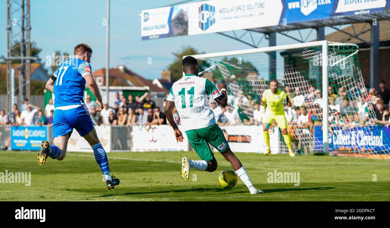 Football (soccer) action from Bognor Regis Town Football Club (Rocks) vs Bishops Stortford. Two players in green and blue strip run towards the goal. Stock Photo