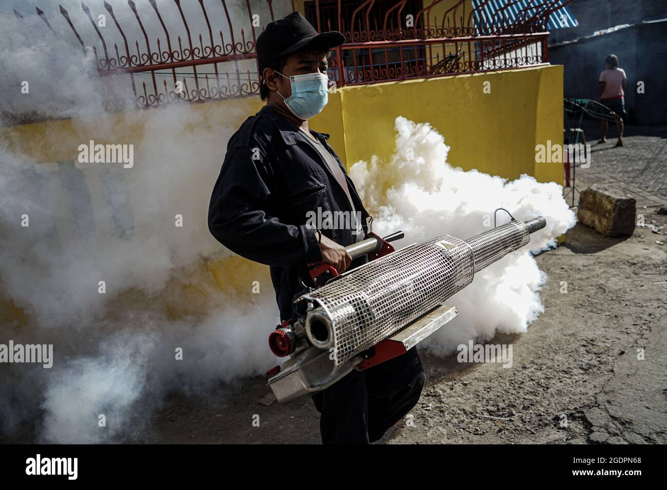 Makassar, South Sulawesi, Indonesia. 14th Aug, 2021. A Makassar City health officer is spraying insecticides to prevent the transmission of diseases caused by mosquitoes such as dengue hemorrhagic fever in a housing complex in Makassar City. The spraying was done because a child in the housing had dengue fever. Cases of dengue hemorrhagic fever began to spread in a number of areas in Indonesia. Therefore, efforts to prevent infectious diseases through eradicating mosquito nests must continue to be encouraged. (Credit Image: © Herwin Bahar/ZUMA Press Wire) Stock Photo