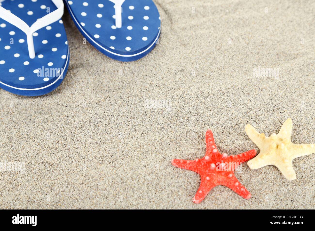 Flip flops on sea sand background Stock Photo - Alamy