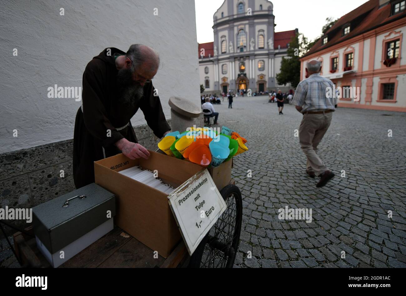 14 August 2021, Bavaria, Altötting A monk sells candles before the beginning of the candlelight