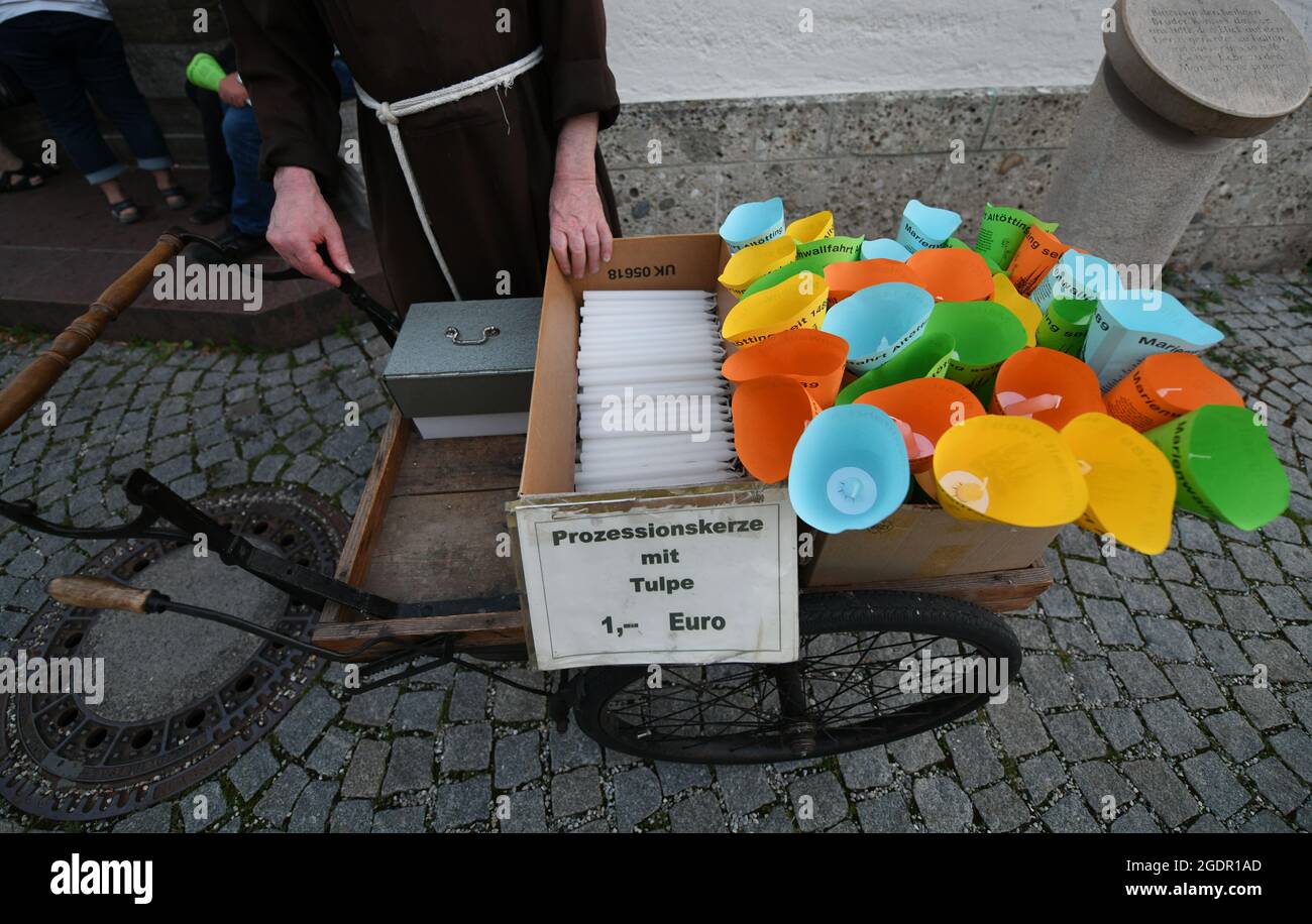 14 August 2021, Bavaria, Altötting A monk sells candles before the beginning of the candlelight
