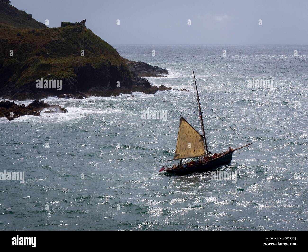 A sailing boat exiting the estuary into the English Channel at Fowey in Cornwall Stock Photo