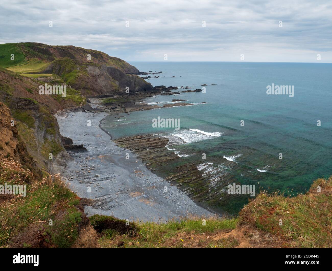 A wave cut platform showing the hard rock on the beach and out to sea in Devon Stock Photo