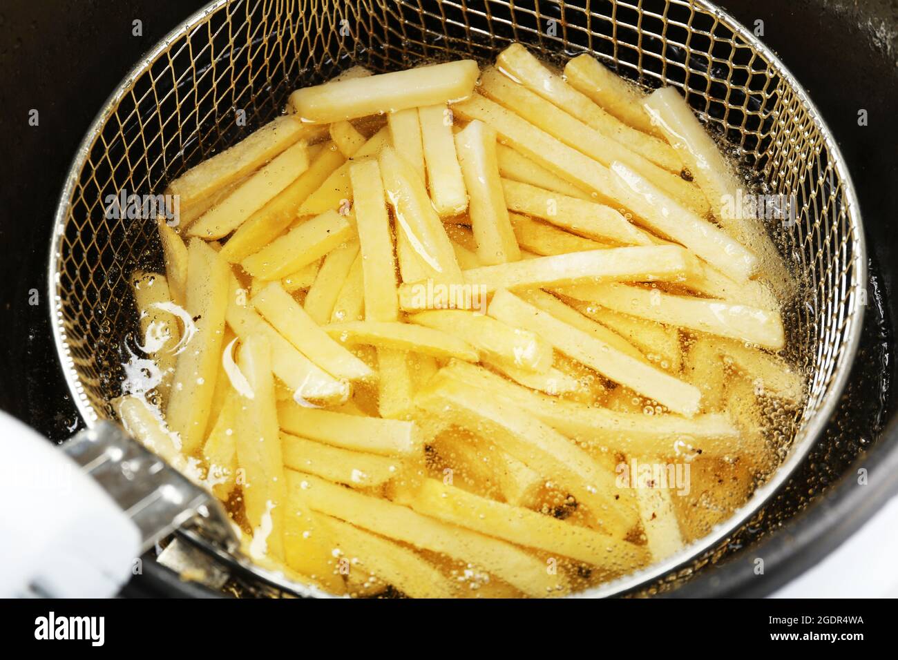 French fries in deep fryer, closeup Stock Photo Alamy