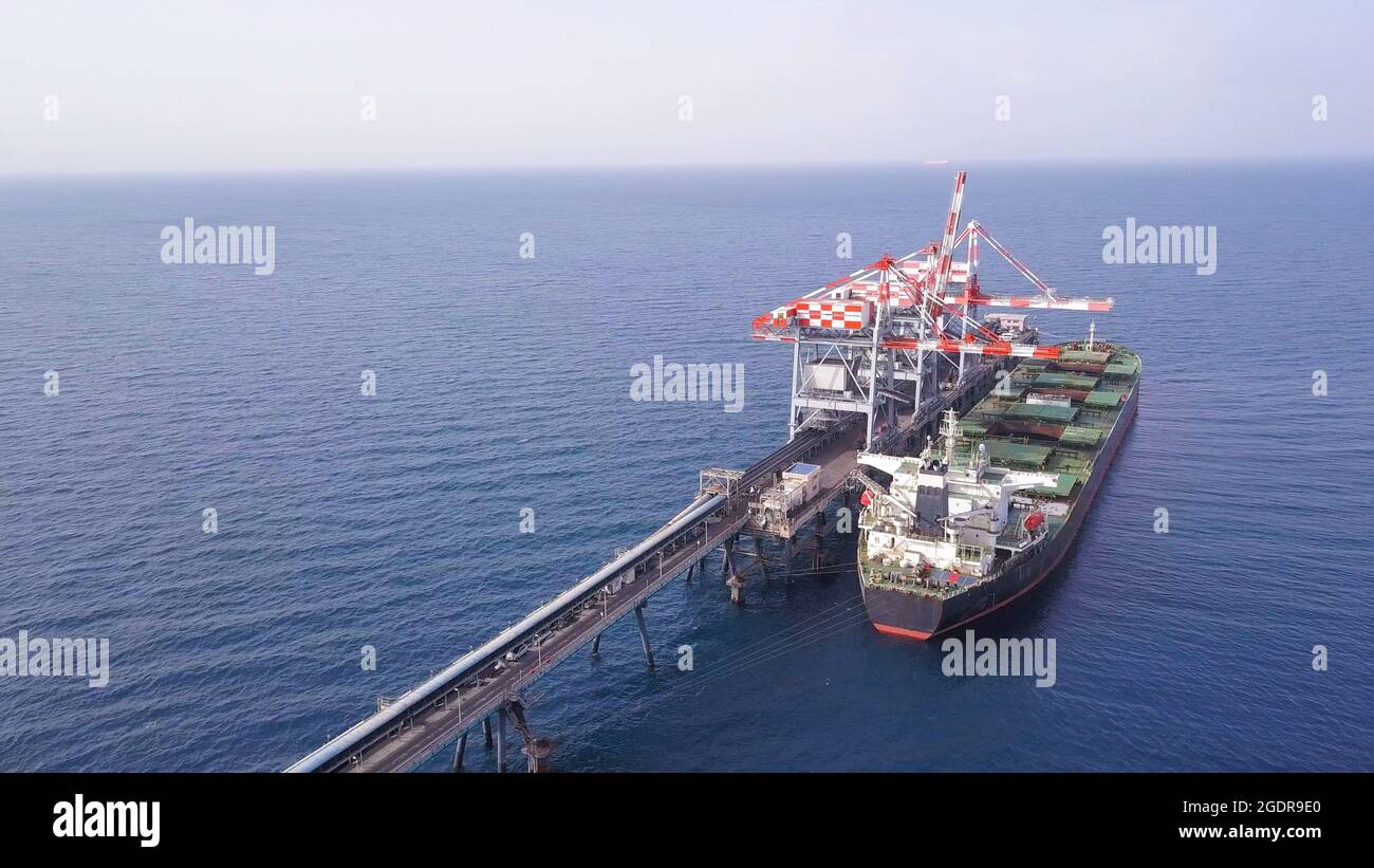 Bulk container ship unloads coal in the port of power station. Stock Photo
