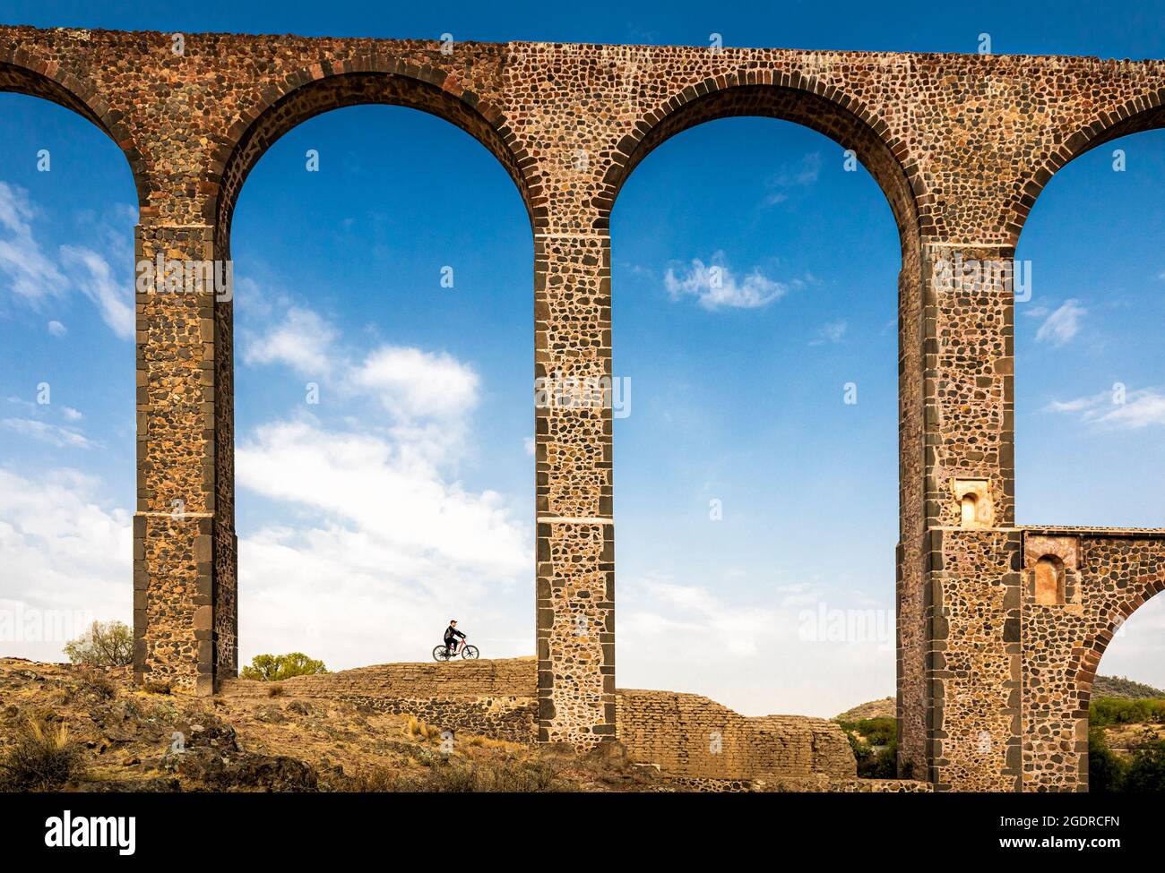 A cyclist admires the Father Tembleque Aqueduct, Hidalgo, Mexico. Stock Photo
