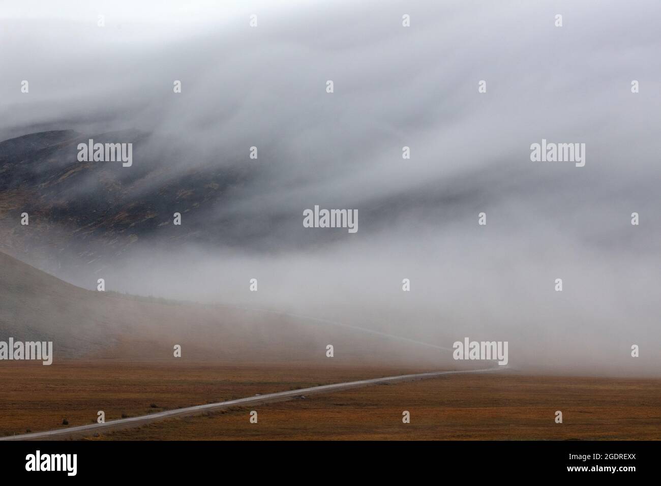 Low, misty clouds cling to the autumn tundra along the desolate Dempster Highway in the Yukon Territory, Canada. Stock Photo