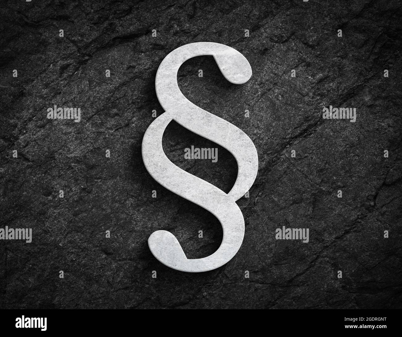 White stone paragraph symbol for law and order on dark stone wall background Stock Photo
