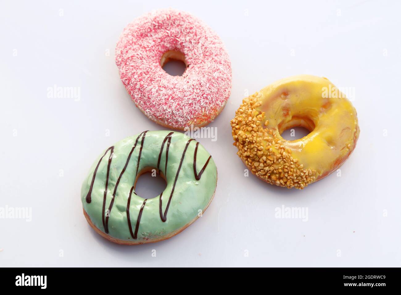 Delicious donuts with color glaze isolated on white Stock Photo - Alamy