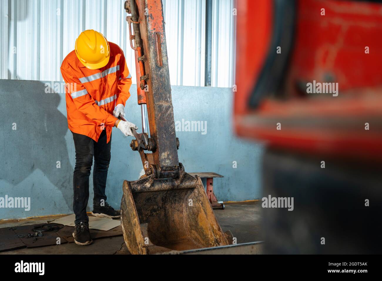 A technician holding a tool for maintenance or excavator at maintenance