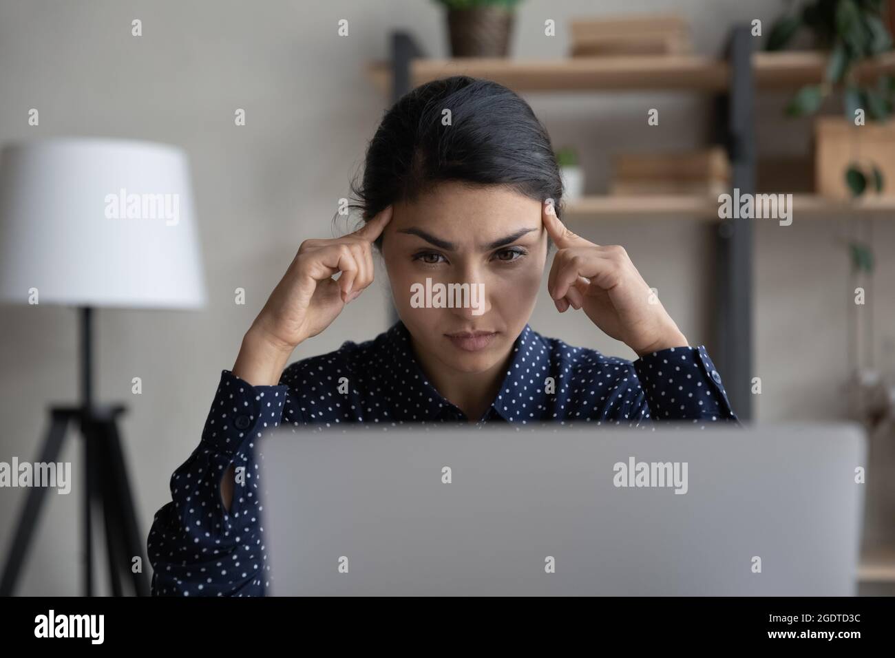 Pensive Indian woman look at laptop thinking Stock Photo - Alamy