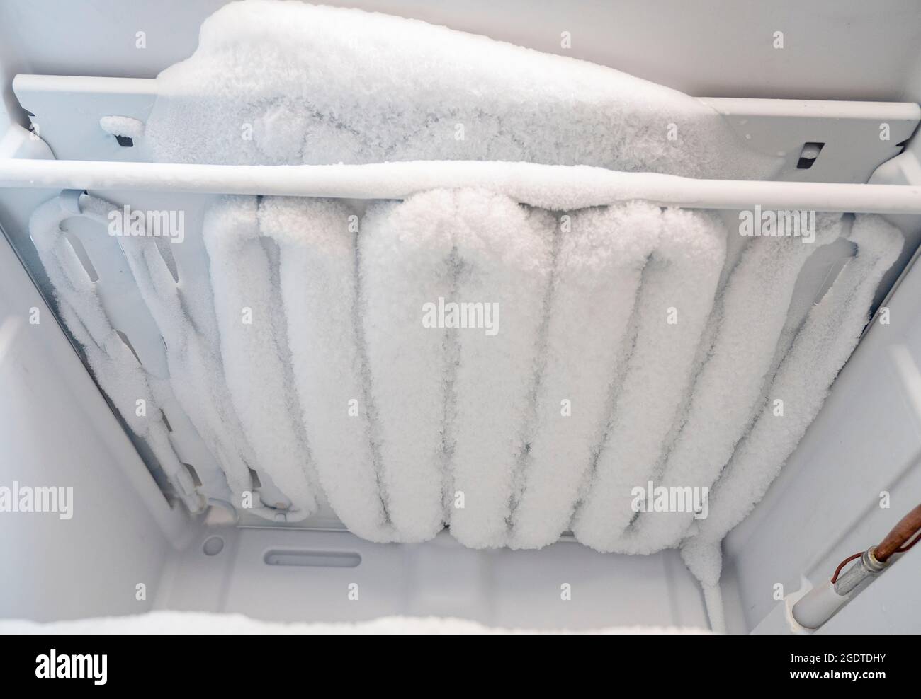 Close-up of opened deep freezer with ice and snow. Freezer before defrost. Empty shelves of fridge. Stock Photo