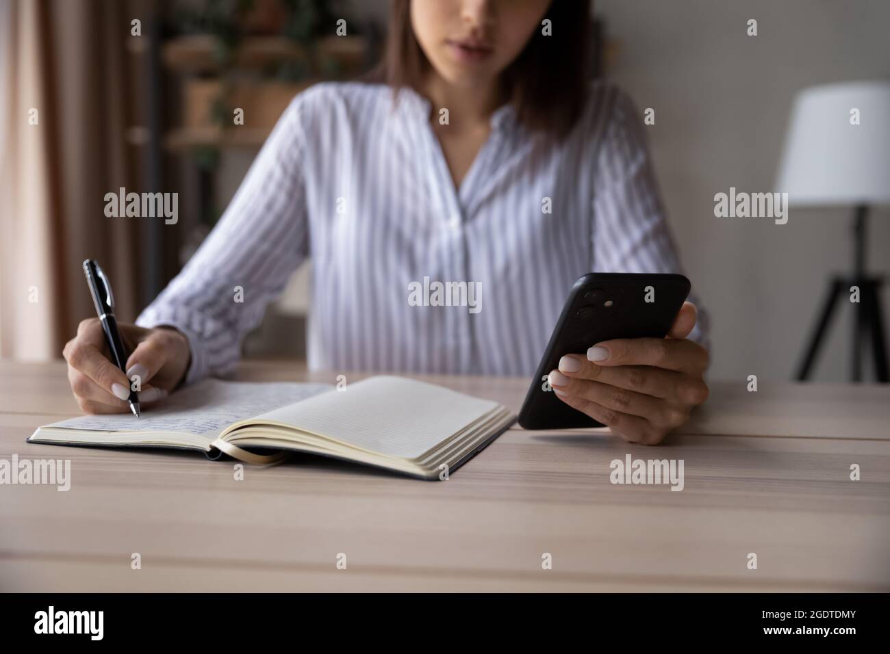 Close up of woman make notes using smartphone Stock Photo