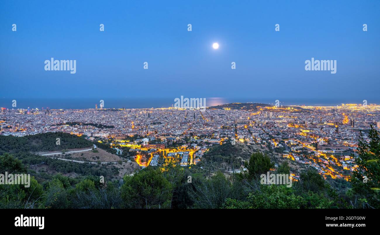 Panorama of Barcelona at night with a full moon Stock Photo
