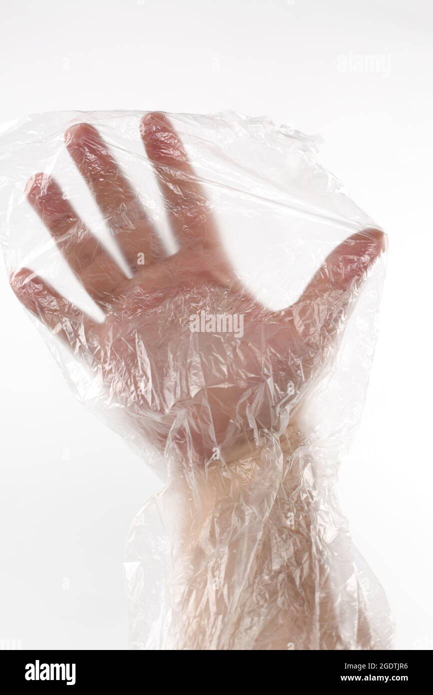 Male hand in plastic wrap. Man's hand in a plastic bag. Male hand inside a transparente wrap bag. Hand of a male wrapped in plastic film. Stock Photo