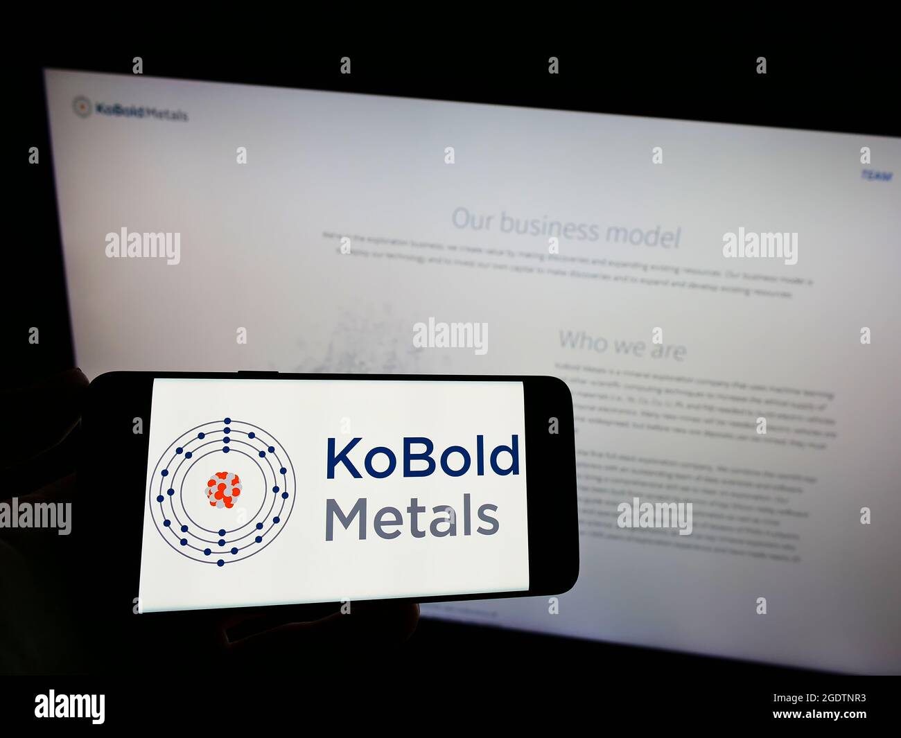 Person holding cellphone with logo of US mining technology company KoBold Metals on screen in front of business webpage. Focus on phone display. Stock Photo
