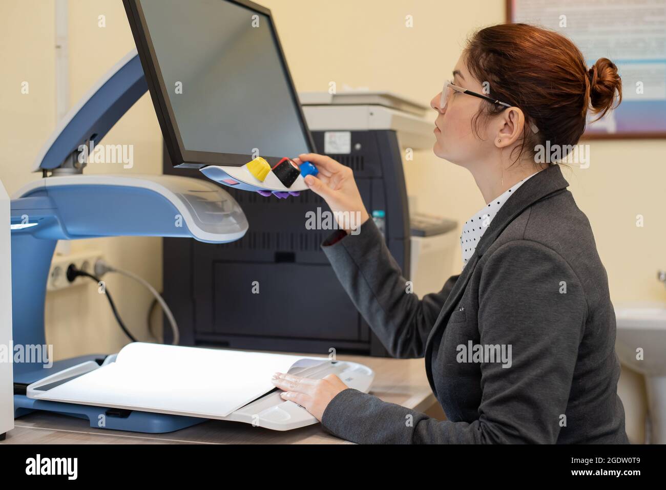 A visually impaired woman uses special reading equipment Stock Photo