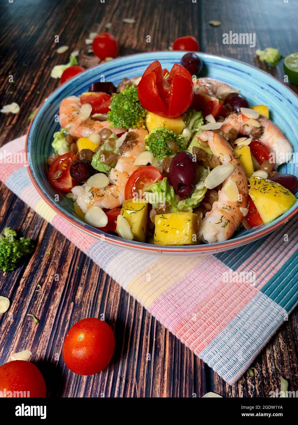 Fresh salad of steamed shrimp,cabbage,avocado,spinach,cherry tomatoes,broccoli,lettuce,cashew,celery,mango,olive Stock Photo