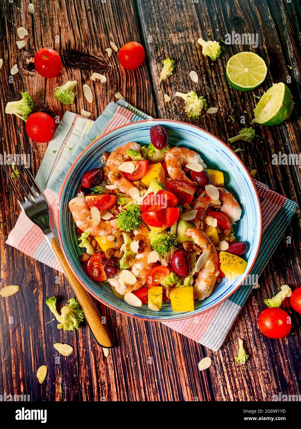 Fresh salad of steamed shrimp,cabbage,avocado,spinach,cherry tomatoes,broccoli,lettuce,cashew,celery,mango,olive Stock Photo