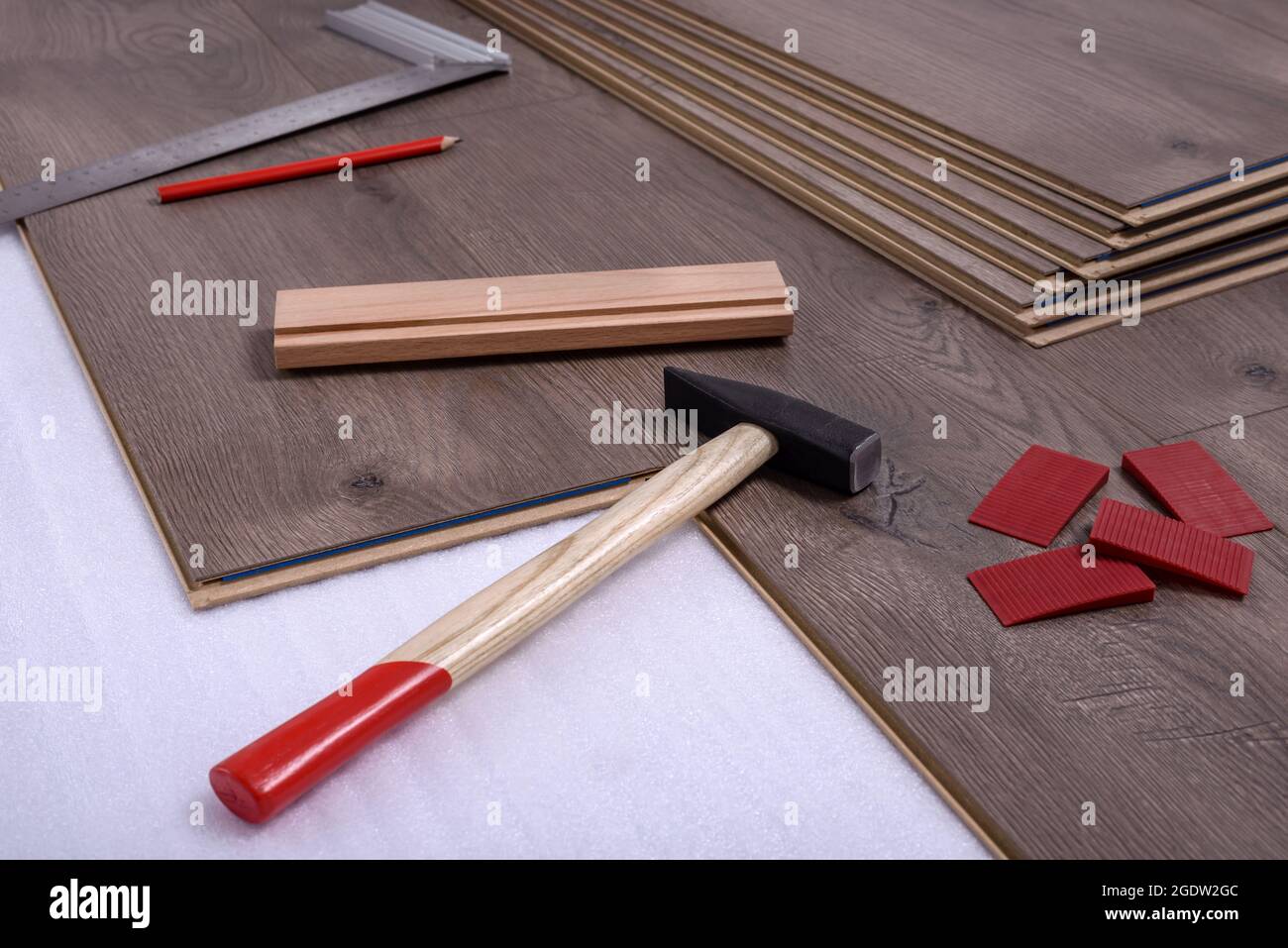 Planks of laminate floor and equipment or tools to install them, hammer