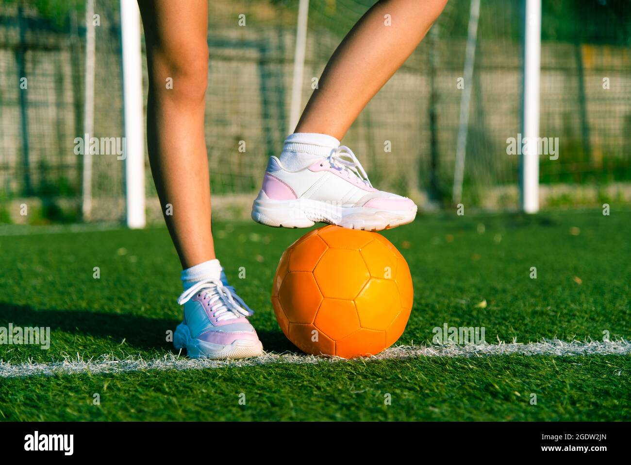 Girl foot stand on the ball, football player field match on stadium. Stock Photo