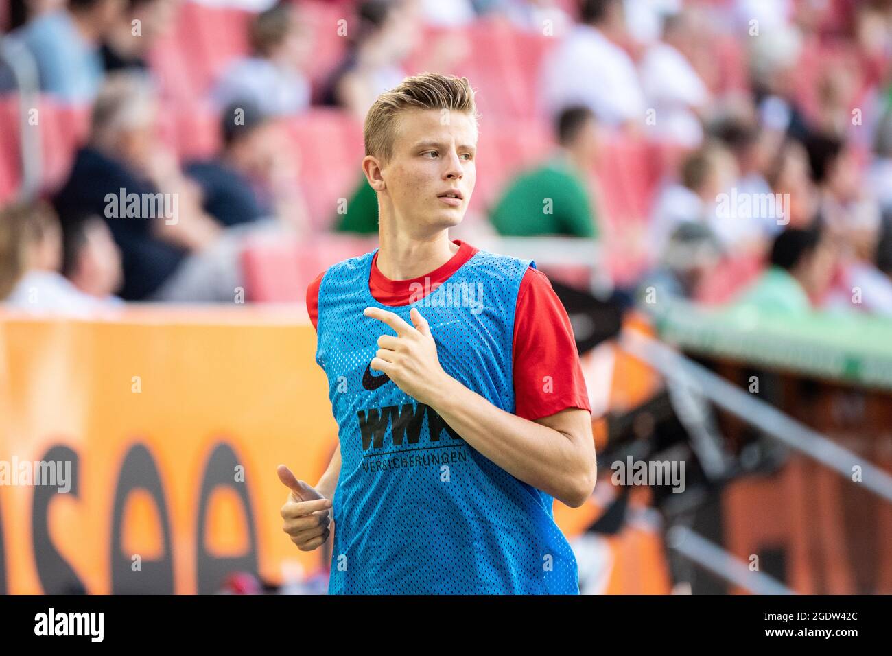 14 August 2021, Bavaria, Augsburg: Football: Bundesliga, FC Augsburg - TSG 1899 Hoffenheim, Matchday 1 at WWK Arena. Frederik Winther of Augsburg warms up on the sidelines. Photo: Matthias Balk/dpa - IMPORTANT NOTE: In accordance with the regulations of the DFL Deutsche Fußball Liga and/or the DFB Deutscher Fußball-Bund, it is prohibited to use or have used photographs taken in the stadium and/or of the match in the form of sequence pictures and/or video-like photo series. Stock Photo