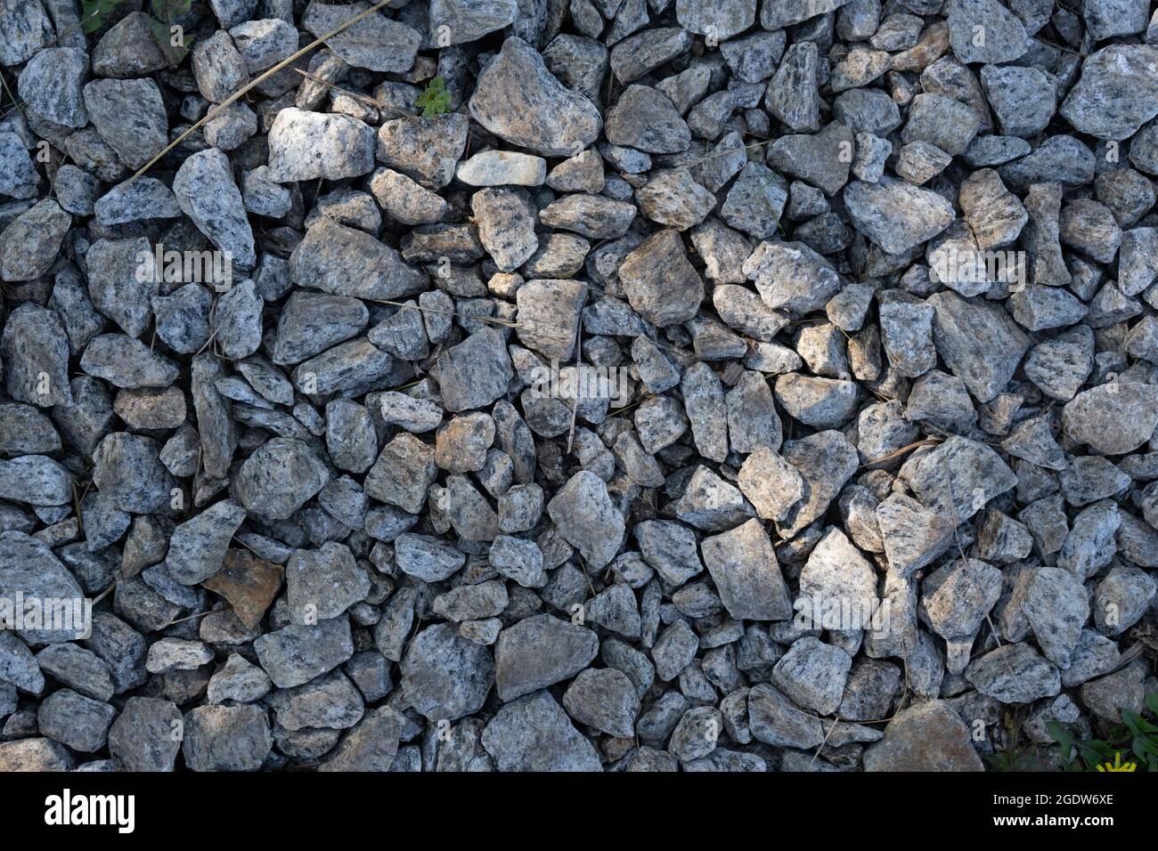 Real backround: grey crushed stones with sunbeam. Stock Photo