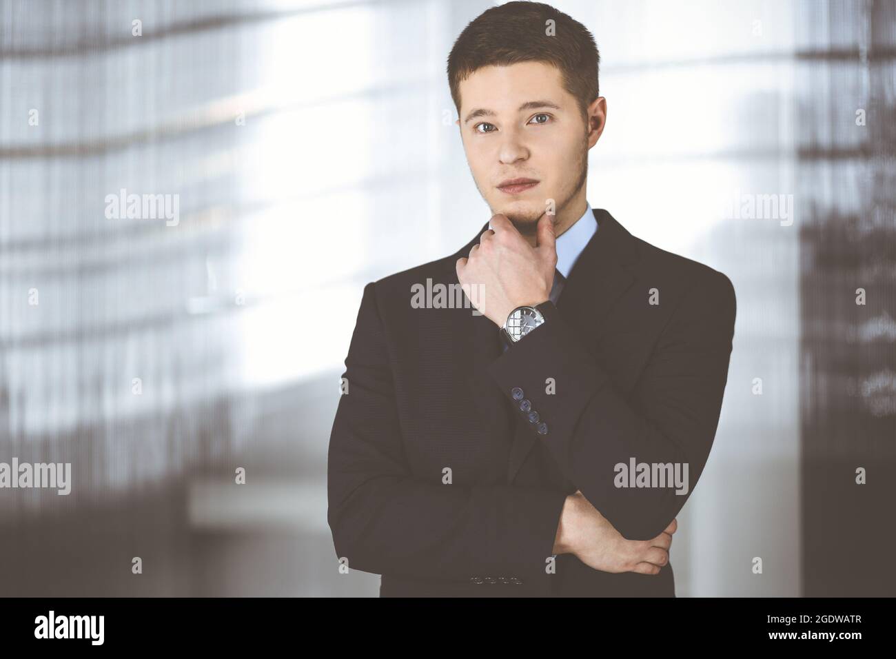 Young businessman wearing suit and tie, while standing in the office ...