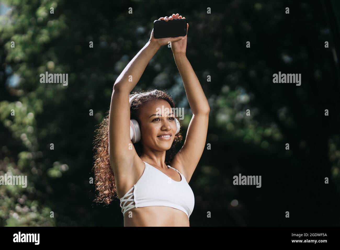 happy athletic woman in headphones standing in the park . close-up. Stock Photo