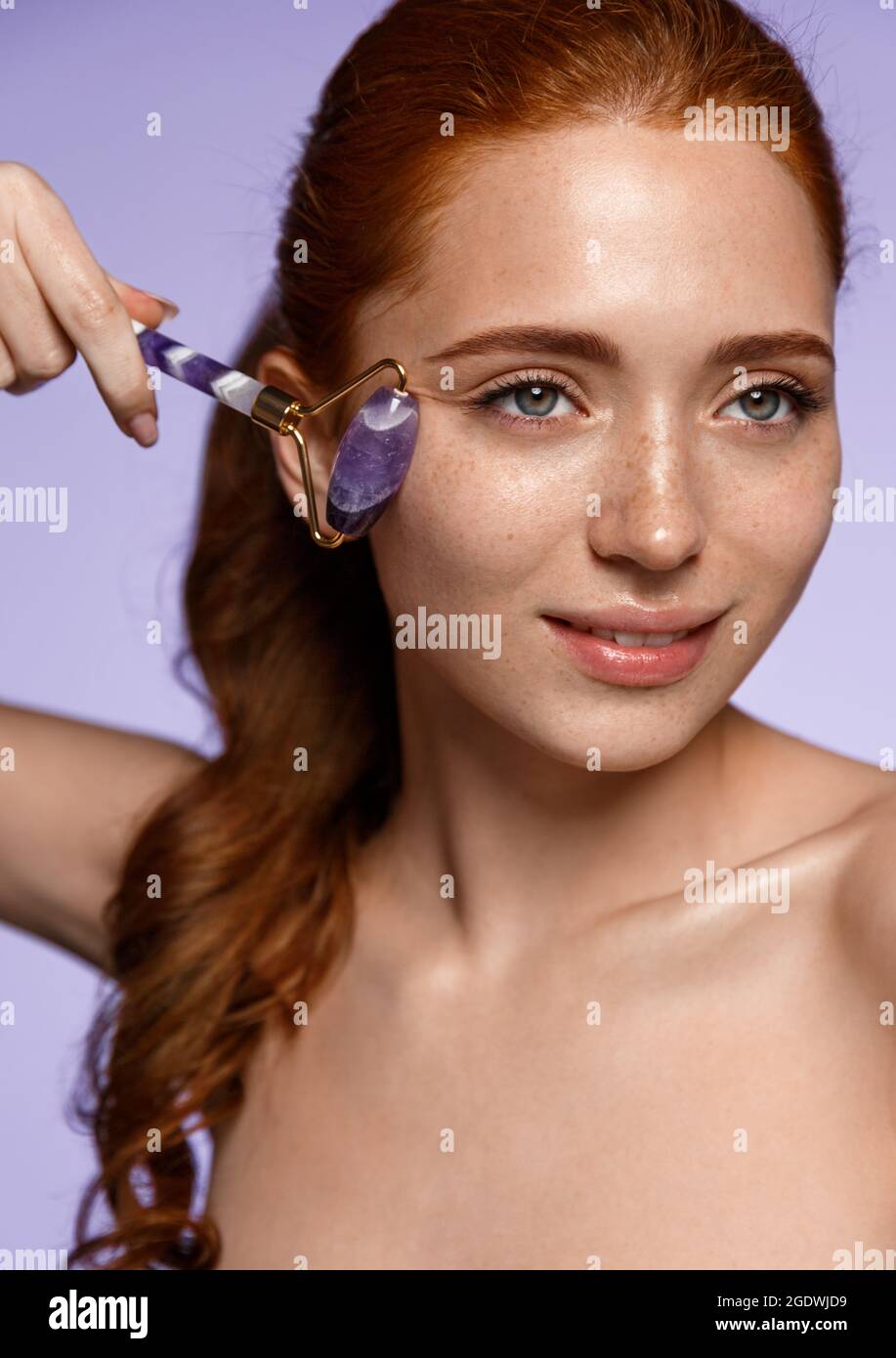 Natural Beauty And Skin Care Concept Portrait Of Smiling Redhead Woman Using Quartz Stone