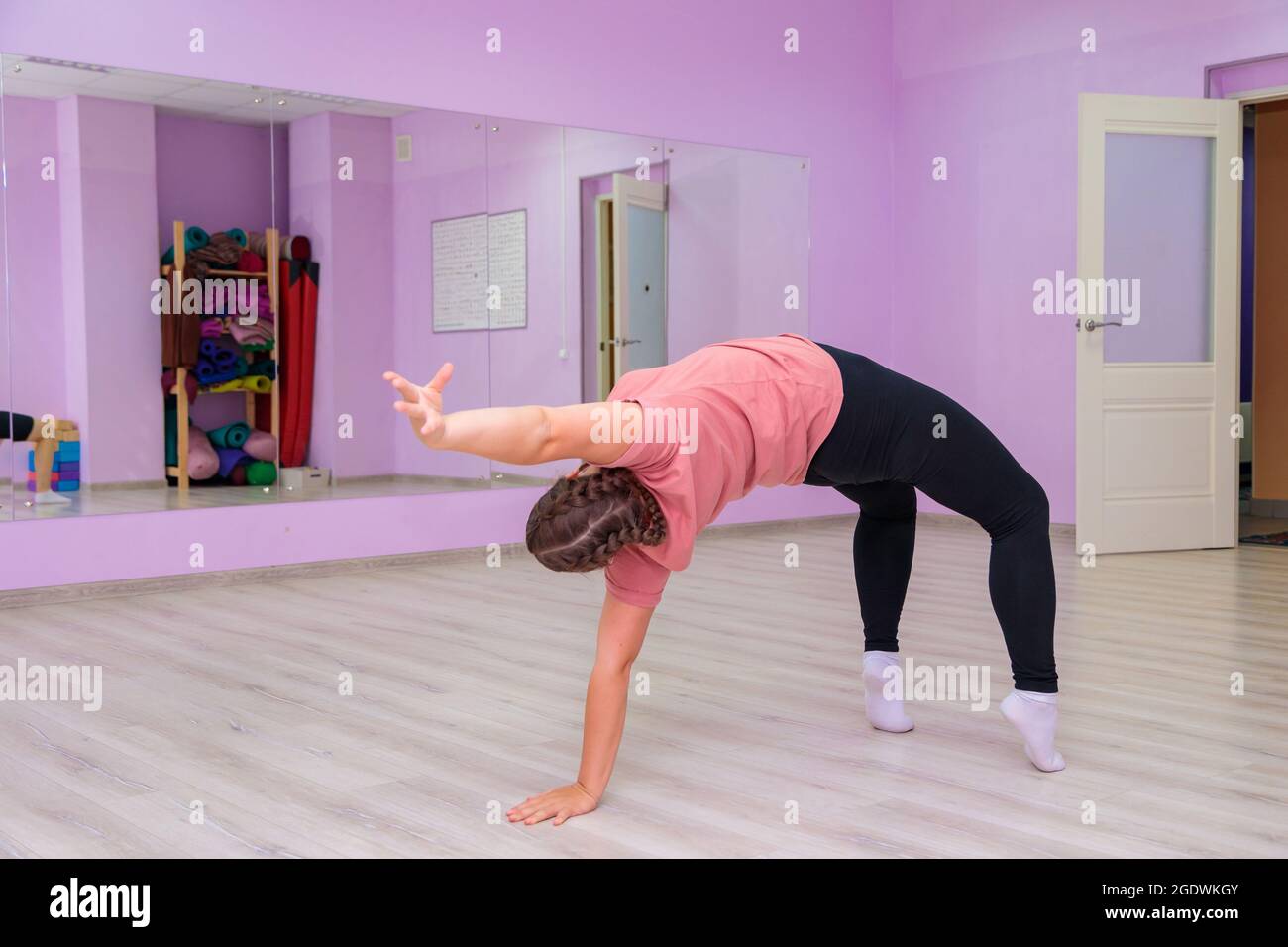 The girl dance instructor shows the elements of the act in front of the mirror. Dance training. Stock Photo