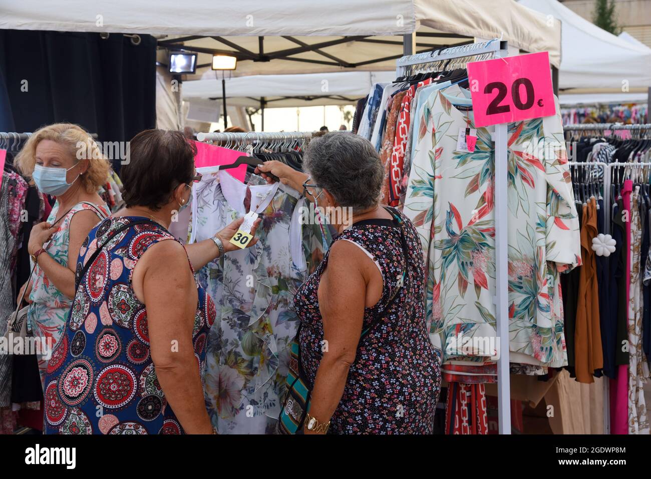 Vendrell, Tarragona, Spain. 5th Aug, 2021. Two women observe the prices of the clothes with discounts sale in the market Out Stocks.The Vendrell Center for Initiatives and Tourism (CIT) organizes the ''Out Stocks Market'' is a help at the end of the summer sales, several clothing and accessories stores set up a stand on the street so that stores have the opportunity to sell the Leftover products from sales to start the new fashion season.The Vendrell Center for Initiatives and Tourism (CIT) is an associative entity that helps and works to promote shops, bars and restaurants and commercial co Stock Photo