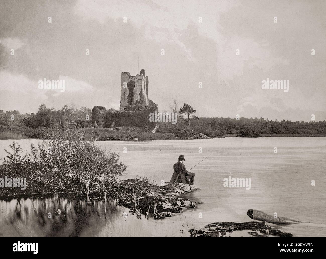 A late 19th century view of a solitary fisherman opposite the ruins of Ross Castle, a 15th-century tower house and keep on the edge of Lough Leane, in Killarney National Park, (Ring of Kerry), County Kerry, Ireland. It was built in by local ruling clan the O'Donoghues Mór (Ross), though ownership changed hands during the Second Desmond Rebellion of the 1580s to the MacCarthy Mór. He then leased the castle and the lands to Sir Valentine Browne, ancestor of the Earls of Kenmare. The castle was amongst the last to surrender to Oliver Cromwell's Roundheads during the Irish Confederate Wars. Stock Photo