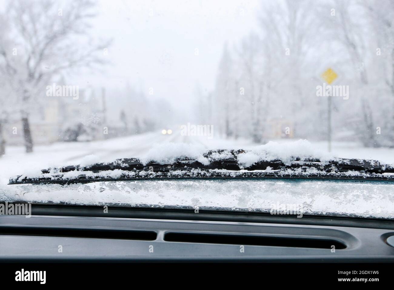 Road covered with snow seen through windshield.  Winter time Stock Photo