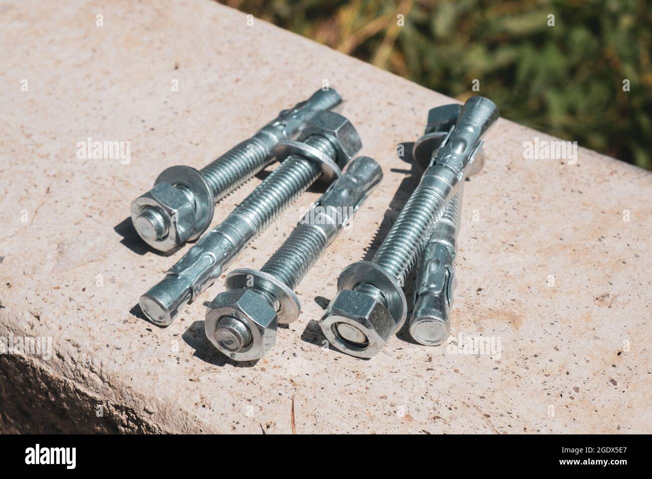 Concrete anchor screws for fixing metal structures isolated group in the concrete wall Stock Photo