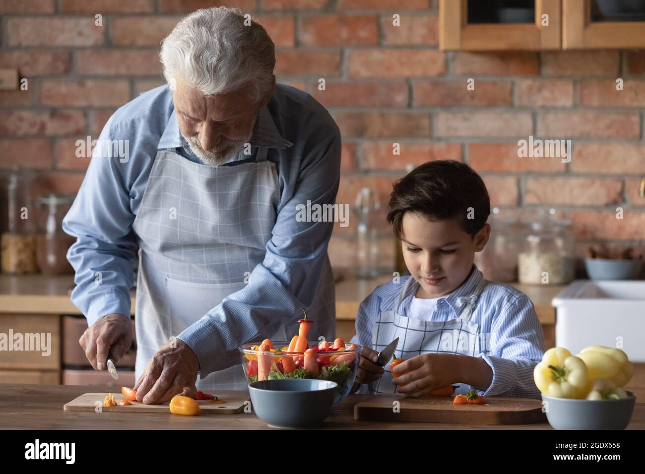 Old grandfather with small grandson cook salad Stock Photo - Alamy