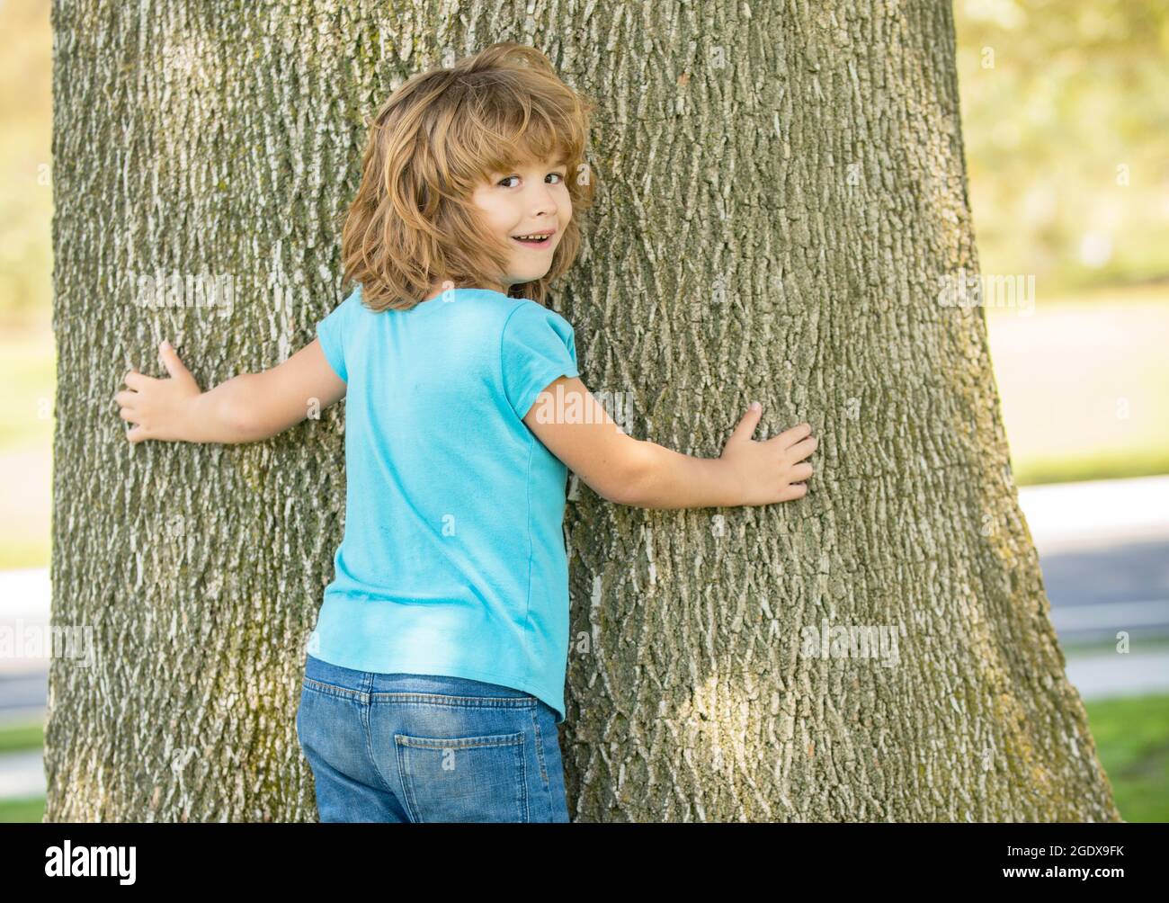 Its so wide. Boy child try to climb tree. Childhood and boyhood. Boyhood days. Tree climbing Stock Photo