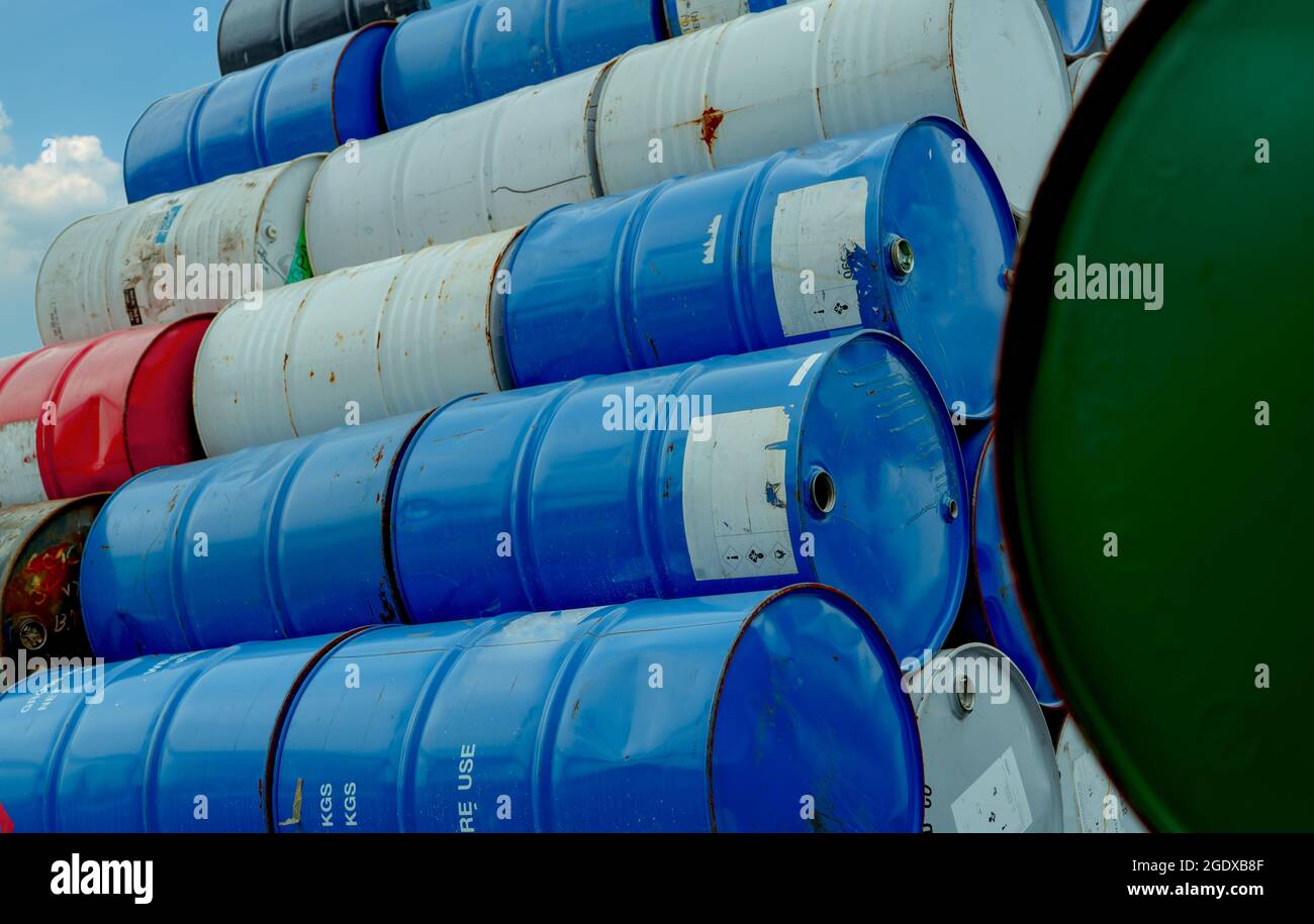 Old chemical barrels stack. Red, green, and blue chemical drum. Steel tank of flammable liquid. Hazard chemical barrel. Industrial waste. Empty Stock Photo