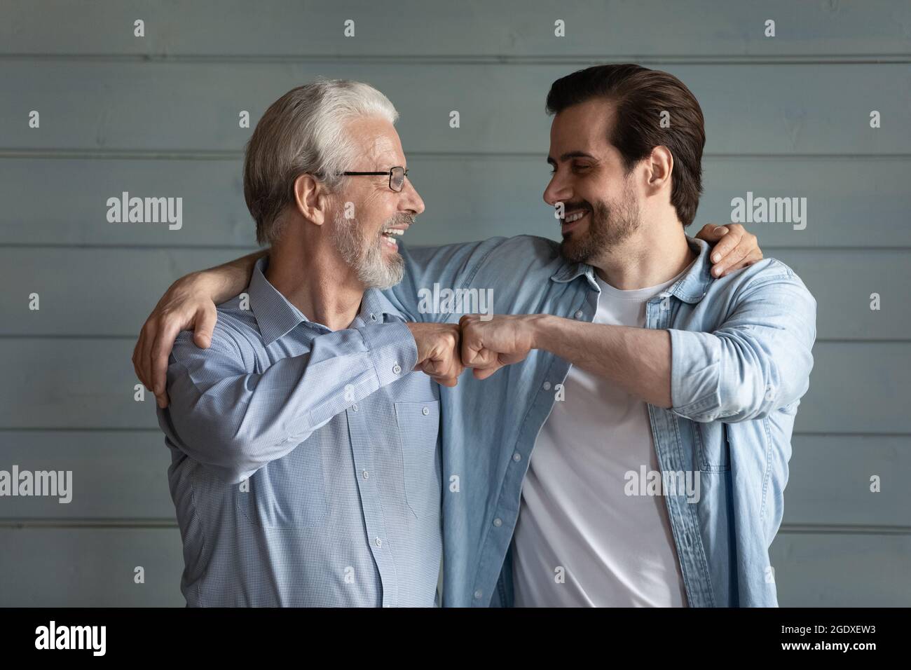 Happy adult son and old dad give fist bump Stock Photo