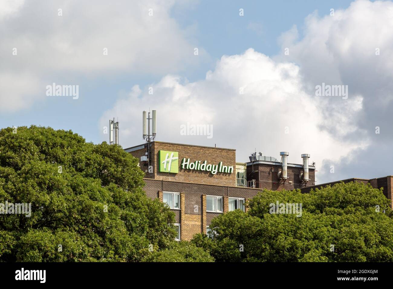 08-12-2021 Portsmouth, Hampshire, UK The Sign of Holiday Inn hotel through trees Stock Photo
