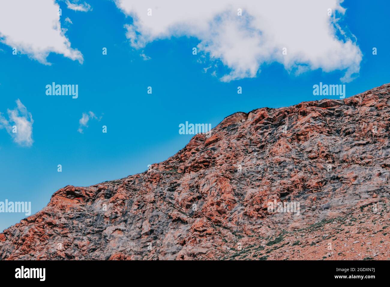 A low angle shot of a big rock under the blue sky with clouds Stock ...