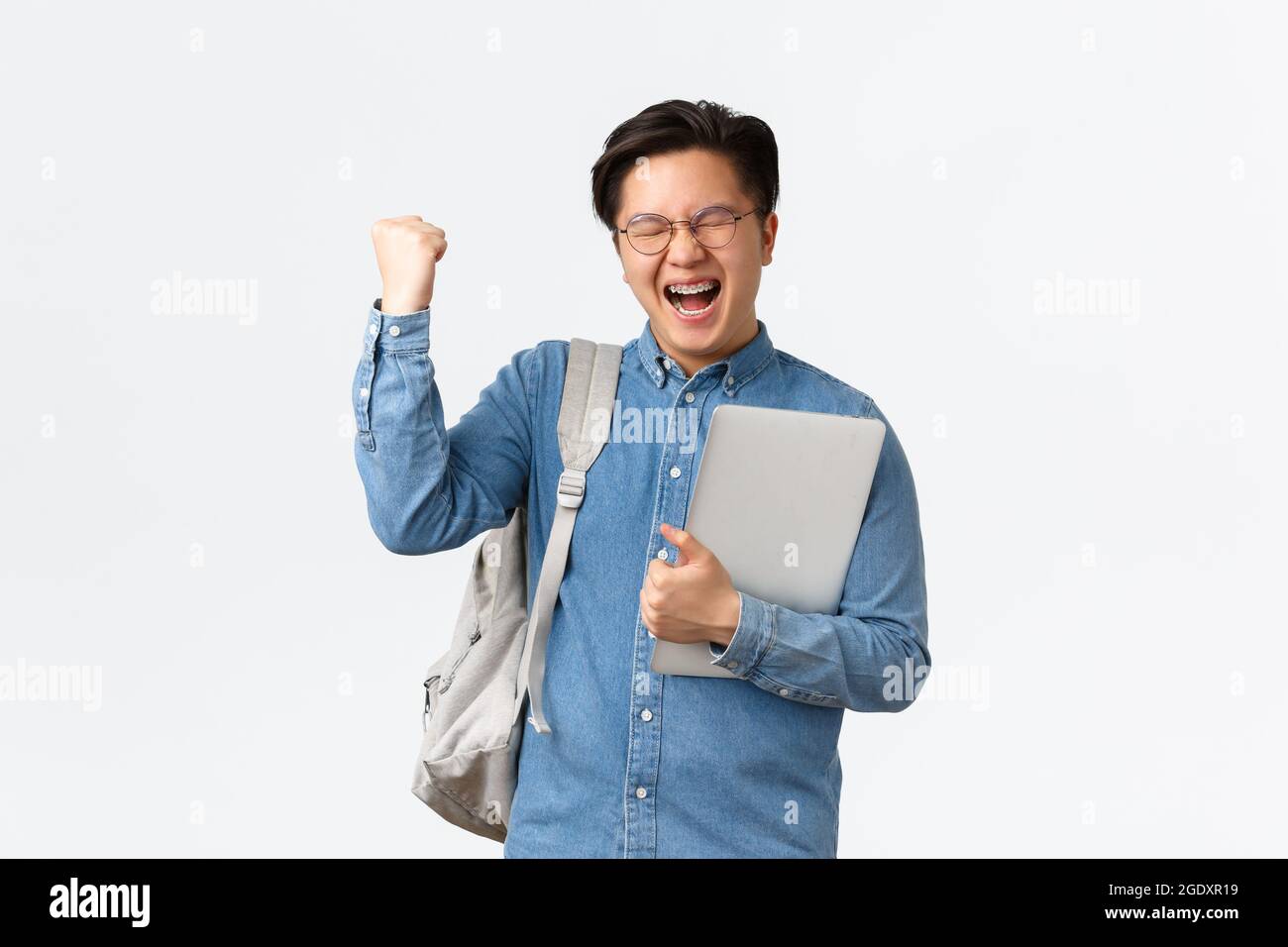 University, study abroad and lifestyle concept. Happy rejoicing asian male student with braces triumphing, pass exams, finish final semester, fist Stock Photo