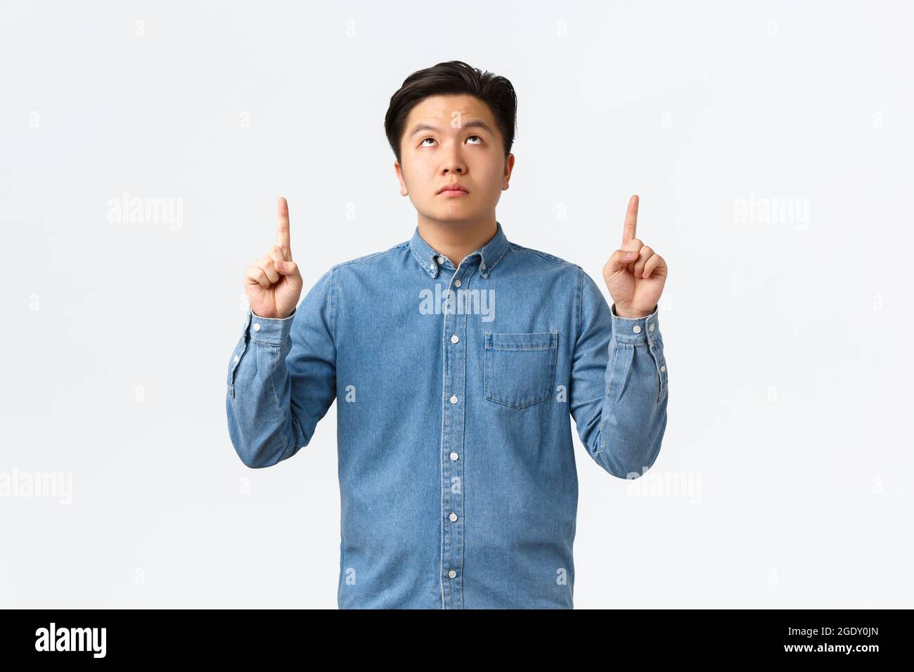 Unamused bored asian guy in blue shirt, looking and pointing fingers up  with poker face, no emotions, being careless about information upwards  Stock Photo - Alamy