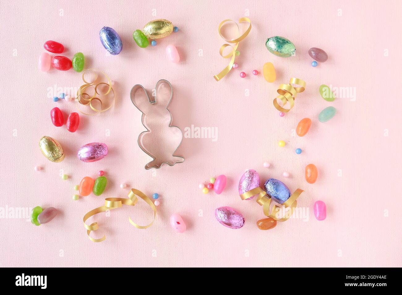 Chocolate Easter eggs and other sweets on pink background. Festive time Stock Photo