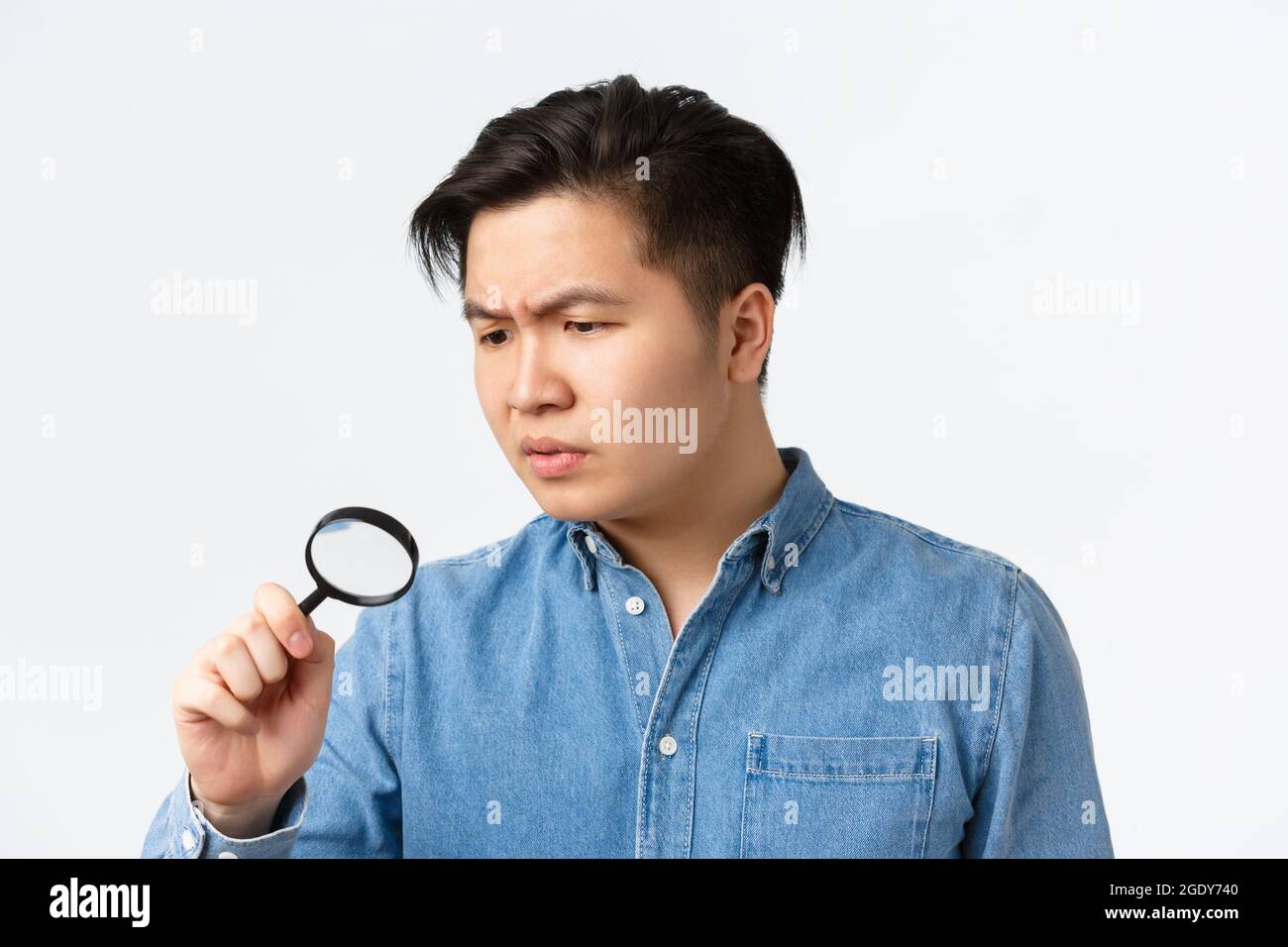 Close-up of serious-looking focused asian man studying something ...