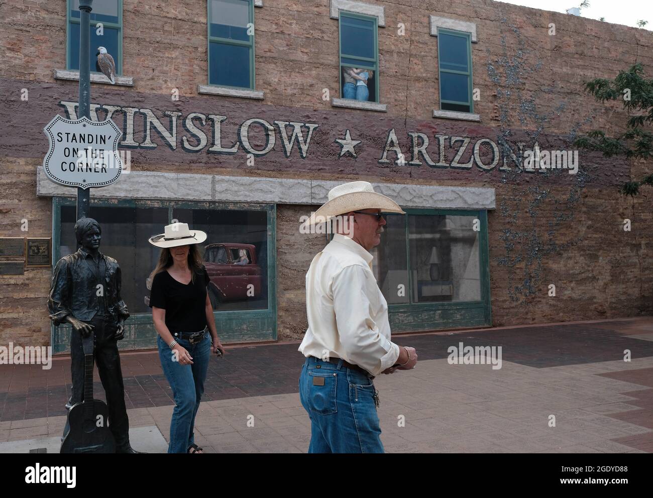 Winslow, Arizona, USA. 12th Aug, 2021. Standin' on the Corner park in Winslow, Arizona. A statue of Eagles member Glen Frey commemorates the 1960's hit song Take it Easy with the line 'well I'm standing on the corner in Winslow, Arizona and such a fine sight to see. It's a girl, my Lord, in a flat bed Ford slowin' down to take a look at me.'' The park contains a two story trompe-l'ceil mural by John Hugh as well as a statue of a man holding a guitar by sculptor Ron Adamson. Winslow is a popular tourist destination on the famed old Route 66 located on the Navajo reservation. (C Stock Photo