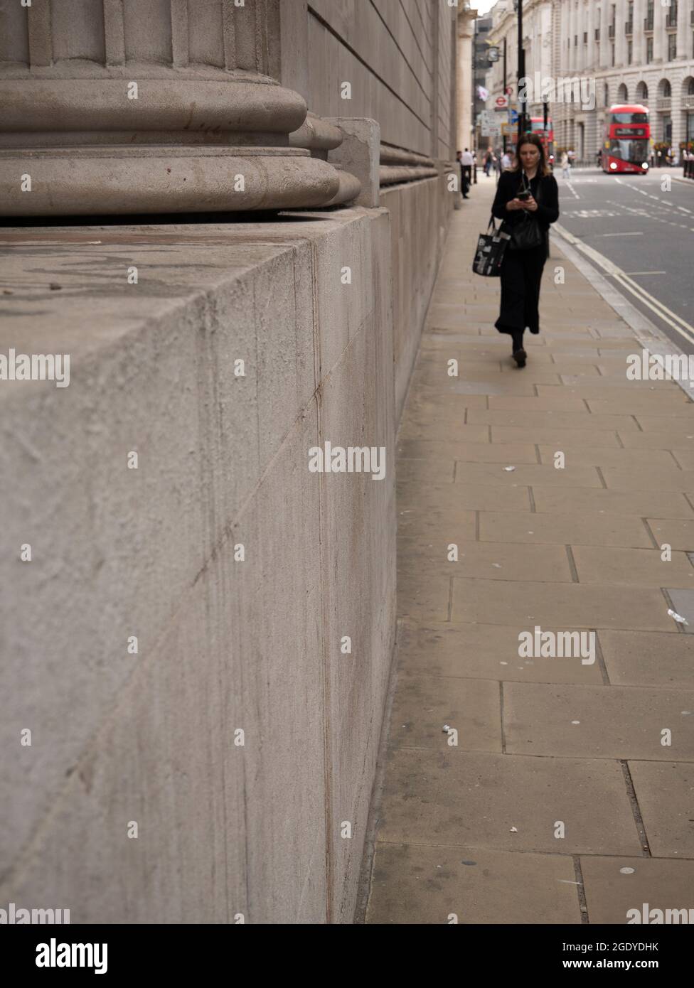 Pedestrian walking down Princes Street, London with the walls of the Bank  of England on left Stock Photo